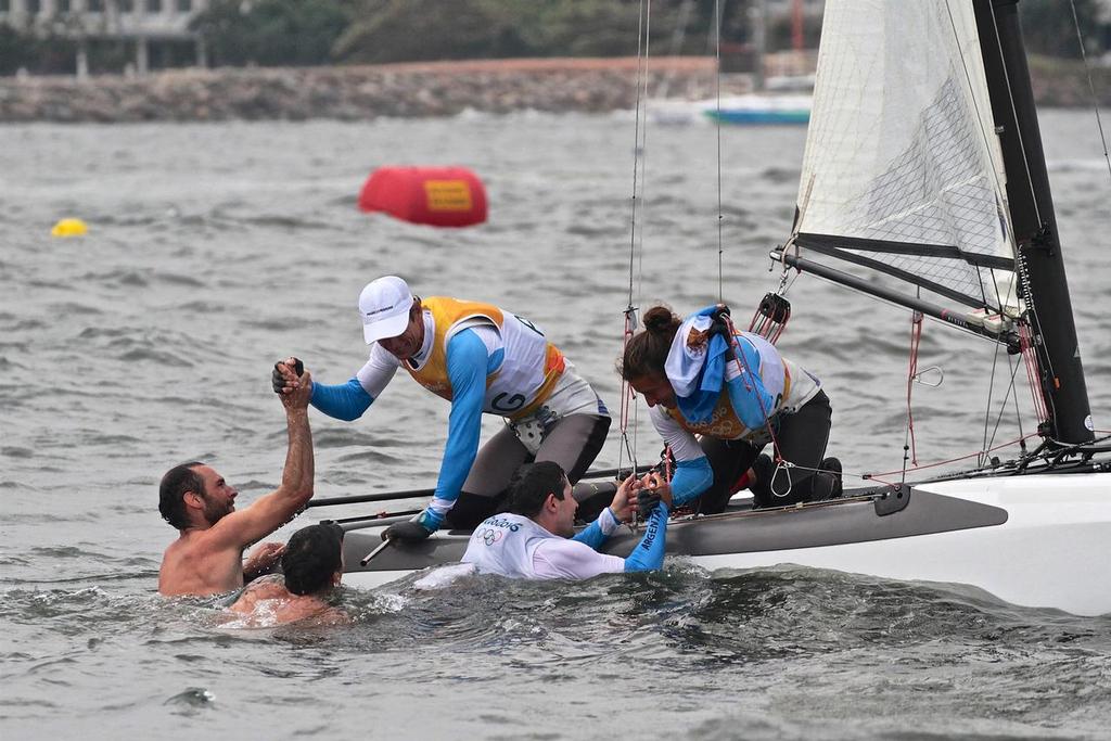 Swimmers come out to Santiago Lange and Cecilia Saroli after their Gold medal win in the Nacra17 class. Medal race 2916 Summer Olympics © Richard Gladwell www.photosport.co.nz